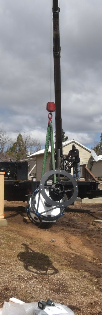 The telescope getting hooked up into a crane ready to be moved into its pier
